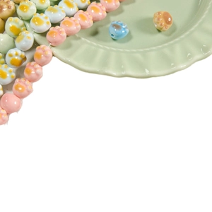 Colorful cat paw ceramic beads for DIY jewelry making in a pastel green ceramic bowl