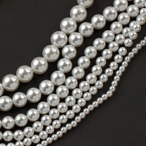 Close-up of white acrylic faux pearls in various sizes for DIY jewelry and accessories