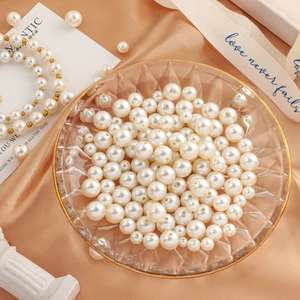 Creamy white ABS faux pearls and handmade bracelet in elegant decorative glass dish