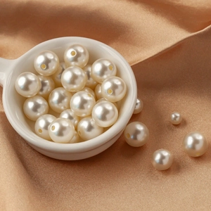 White acrylic pearl beads for DIY jewelry making on soft silk champagne background