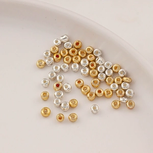 Mix of gold and silver plated glass spacer beads for DIY jewelry making on white plate
