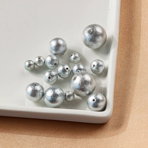 Detailansicht grauer japanischer Baumwollperlen mit Loch für handgefertigten DIY-Schmuck