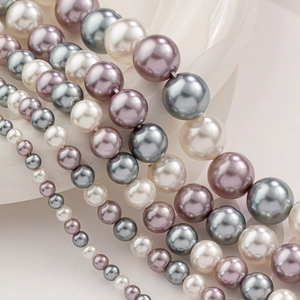 Gros plan de perles en verre de 4-12mm en blanc, violet clair et gris foncé pour bijoux