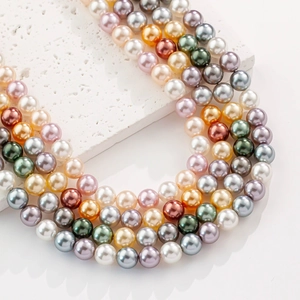 Mélange de perles rondes en verre colorées avec finition brillante sur pierre blanche