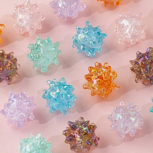 Close-up of assorted colorful iridescent thorn ball beads for DIY jewelry and hair accessories