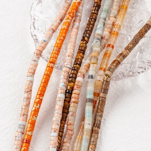 Mix of colorful 4x2mm natural stone wheel beads arranged on a textured glass plate
