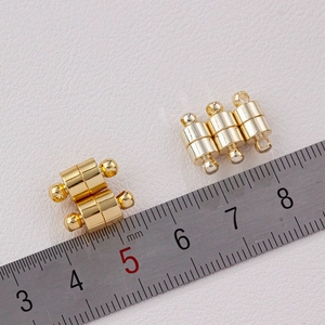 Close-up of 10mm gold barrel magnetic jewelry clasps with ruler for size measurement