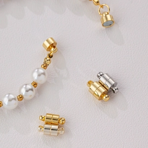 Macro detail of gold and silver magnetic jewelry clasps attached to a pearl necklace