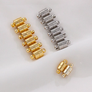 Macro shot of 14K gold plated multi-strand magnetic jewelry clasps on white fabric