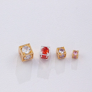 Gedetailleerde macro-opname van kubieke vergulde kralen met gekleurde zirkoon voor DIY-sieraden