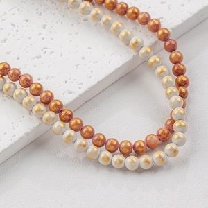 Handmade beaded necklace featuring red and white ceramic beads with gold cloud patterns