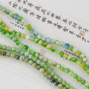 Macro shot of natural green jade beads with elegant marbled texture for jewelry making
