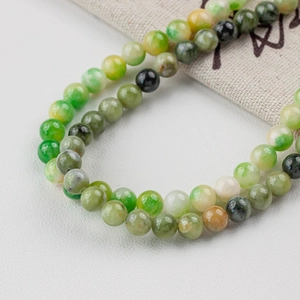Close-up of green natural jade round beads for DIY jewelry with elegant stone textures