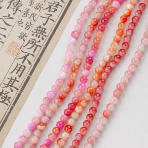 Close-up of polished pink and peach round beads for DIY jewelry with natural texture