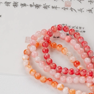 Detailed view of pink natural jade round beads on traditional calligraphy art paper