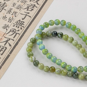 Green and blue natural marble texture stone bead bracelet on white leather background