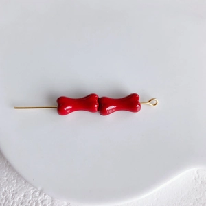 Détail des perles en alliage rouges en forme d'os sur tige dorée pour bijoux DIY