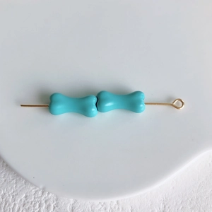 Vue macro de perles d'os bleues sur tige dorée pour matériel de bijoux DIY