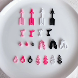 Detailed view of pink and white enamel alloy charms for DIY jewelry making