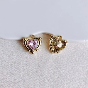 Detailansicht der rosa Herzanhänger mit Goldlegierungsrahmen und Waben-Rückseite
