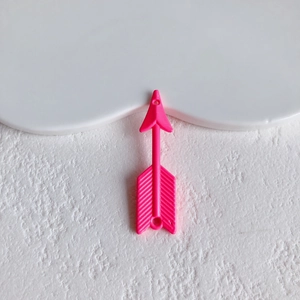 Macro detail of pink arrow-shaped resin charms with vertical texture for DIY crafts