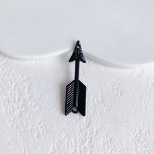 Detail of black metal arrow pendant with dual holes for DIY jewelry making