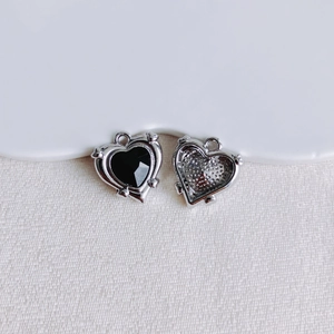 Makro-Detail von Herzanhängern aus Legierung mit schwarzem Stein und Silber-Finish