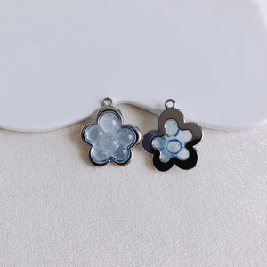Makro-Detail von Blumenanhängern aus Legierung mit blauem Harz für DIY-Schmuck