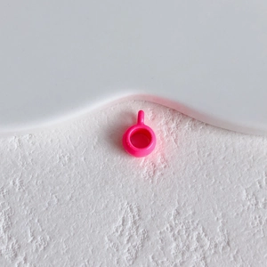 Macro shot of bright pink music note shoe charm with a small loop for DIY jewelry