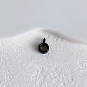 Glossy black ring pendant charm for DIY jewelry making on stone texture surface