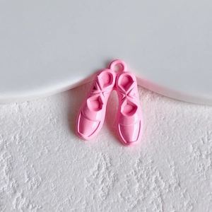 Macro shot of pink enamel ballet shoe pendants for DIY jewelry making and crafts
