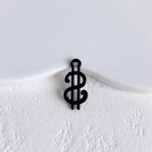 Close-up of black dollar sign metal charm with a glossy finish for DIY jewelry crafts