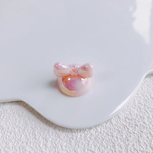 Close-up of pink and purple gradient bow acrylic charm with iridescent laser finish