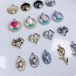 Detaillierte Makroansicht von verschiedenen Emaille-Blumen-Anhängern mit Perlen für DIY-Schmuck
