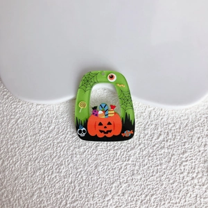 Dettaglio del ciondolo di Halloween in acrilico verde con zucche e motivi di dolci