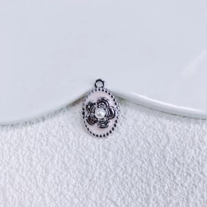 Makroaufnahme von ovalem Blumenanhänger mit Perle und rosa Emaille für DIY-Schmuck
