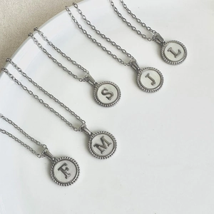 Stainless steel alphabet pendant necklaces with freshwater shell inlay on white tray