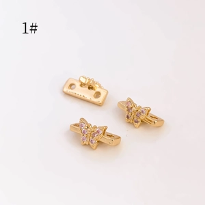 Vista macro de cuentas de mariposa chapadas en oro con circonitas rosas para joyería DIY