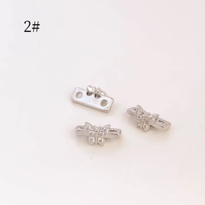 Detalle de dijes de mariposa plateados con circonitas y bases espaciadoras de perlas