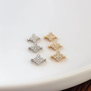 Macro view of gold and silver plated four-petal flower connectors with pavé cubic zirconia