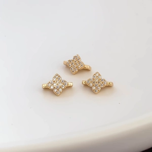 Macro shot of 18k gold plated four-petal flower connectors with micro-pave cubic zirconia