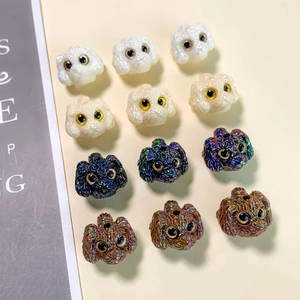 Close-up of curly dog-shaped resin beads in four colors for DIY jewelry making