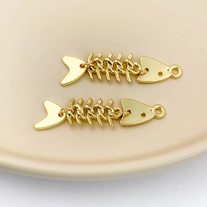 Portachiavi a spina di pesce dorati su un vassoio di ceramica beige in stile minimalista