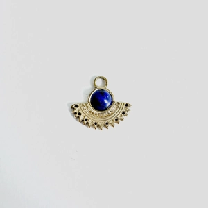 Macro detail of fan-shaped gold stainless steel pendant with blue lapis lazuli stone