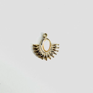 Detailed view of a gold-tone fan-shaped pendant with an oval yellow natural stone inlay