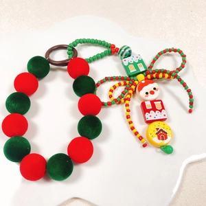Détail de dragonne de téléphone de Noël avec boules floquées rouges et breloques de fête