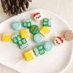 Vue macro de perles de Noël avec motifs Père Noël et flocons sur une assiette en céramique
