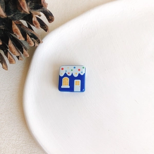 Gros plan de perles maison enneigée bleue pour bijoux de Noël sur plateau blanc
