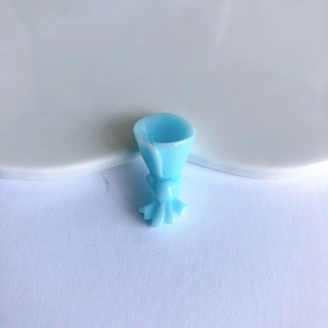 Close-up of light blue resin flower bouquet charm with bow knot for DIY accessories