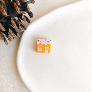 Détail macro d'une perle orange carrée avec motif maison en pain d'épices pour bijoux